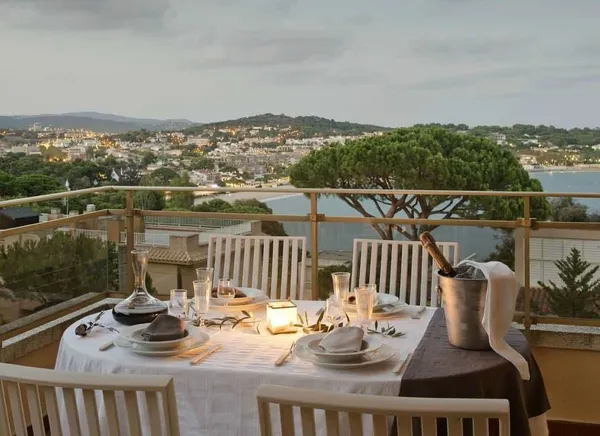 Mesa preparada para cenar en la terraza al atardecer