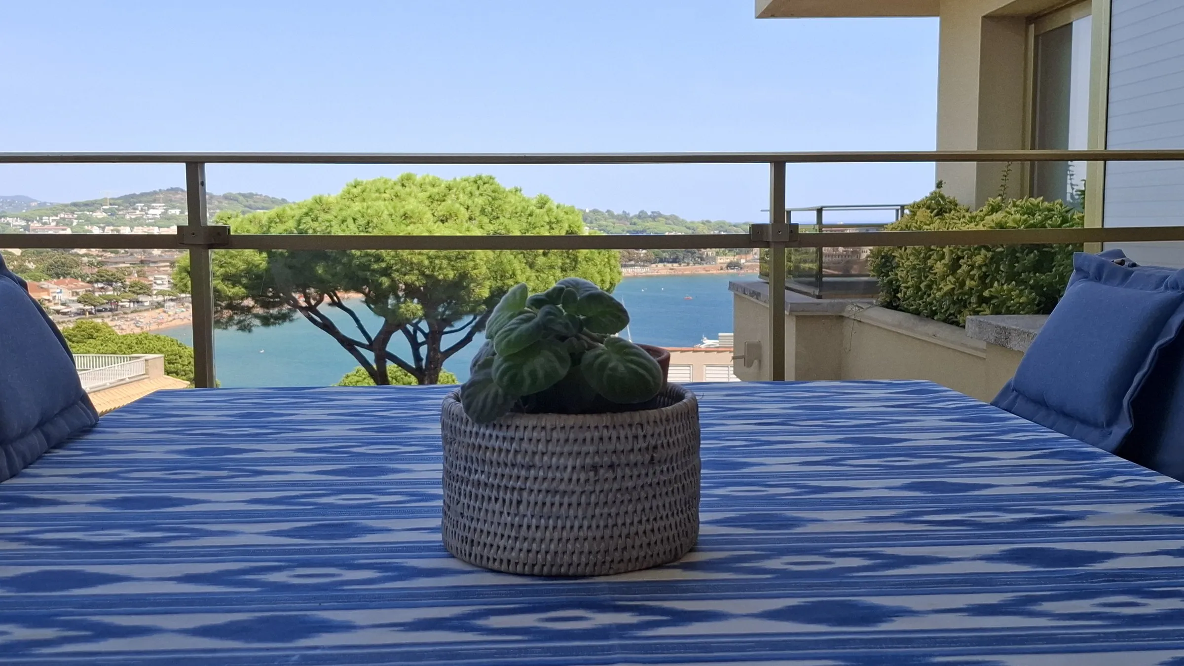Mesa de la terraza con cojines azules y el mar al fondo